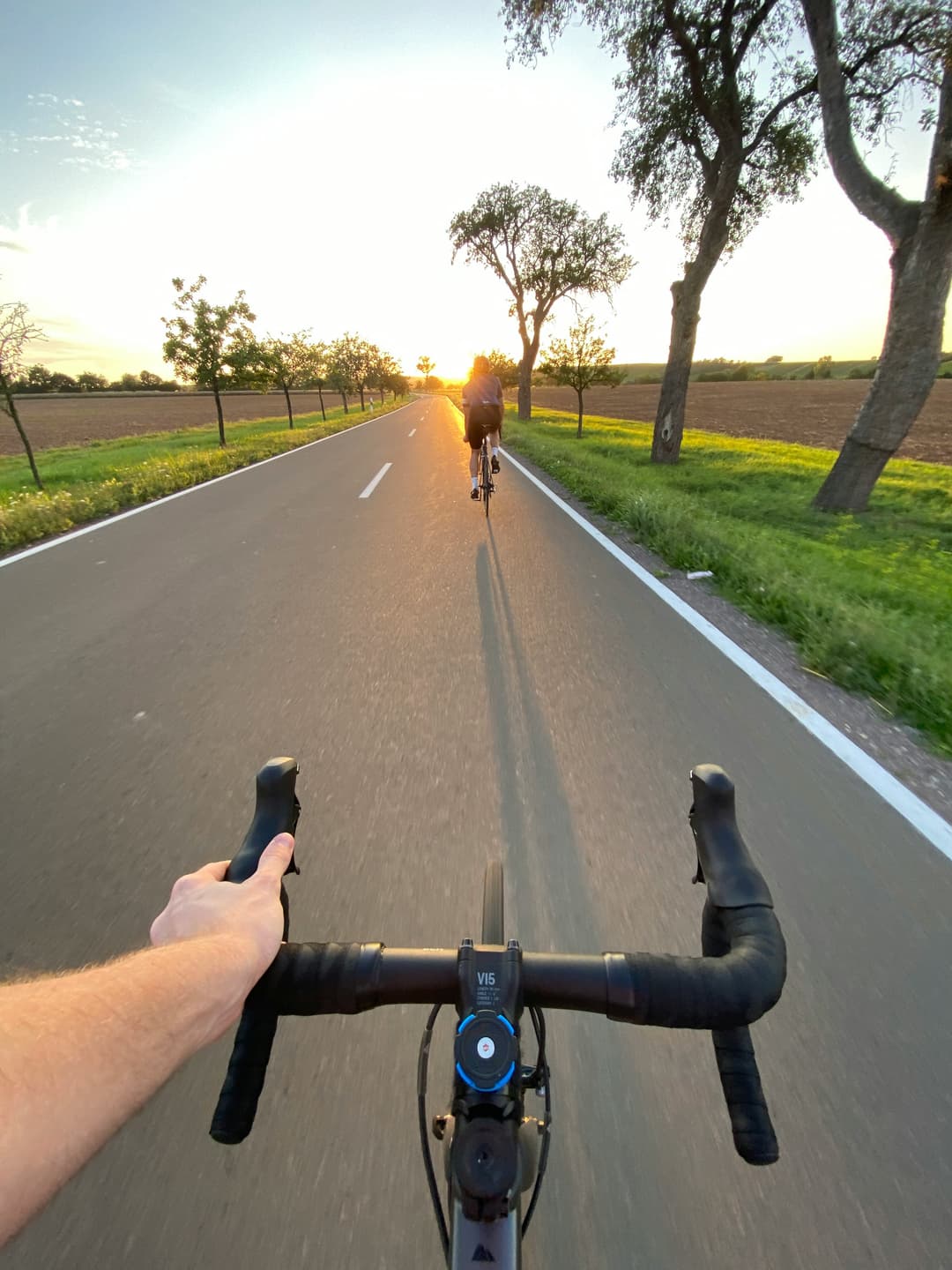 An image of someone cycling into the sunset